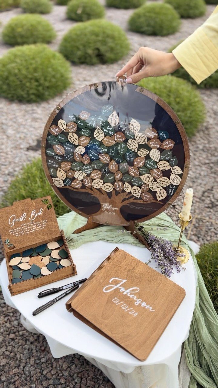 Wooden guest book station with a leaf-token tree and personalized engraved album.