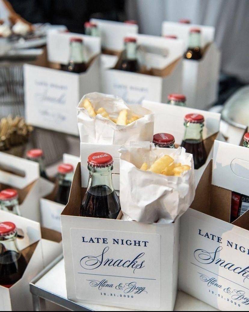 Individual white snack boxes with french fries and Coca-Cola bottles for wedding guests.