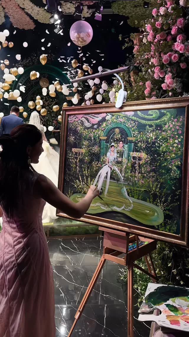 Artist painting a live wedding portrait of a couple at a decorated celebration.