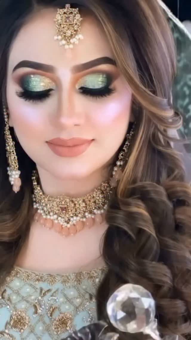 Woman with shimmering green bridal eyeshadow and traditional gold and pearl jewelry