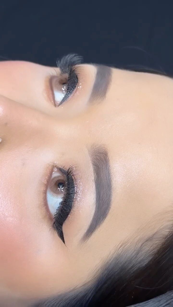 Eyes with shimmering silver eyeshadow, sharp black winged eyeliner and long dark lashes.