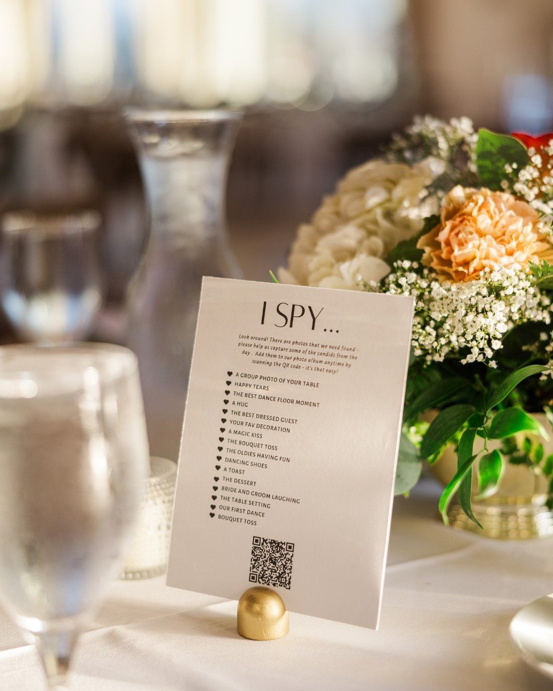 Wedding I Spy game card on a table next to floral centerpieces