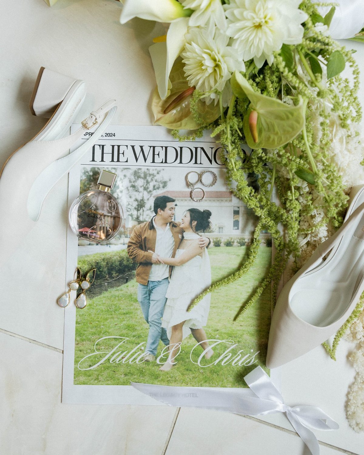 Wedding newspaper with a couple's photo surrounded by white flowers and bridal shoes.