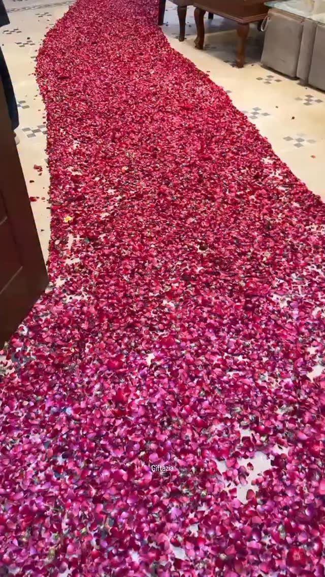 Red and pink rose petals forming a path on a tiled floor