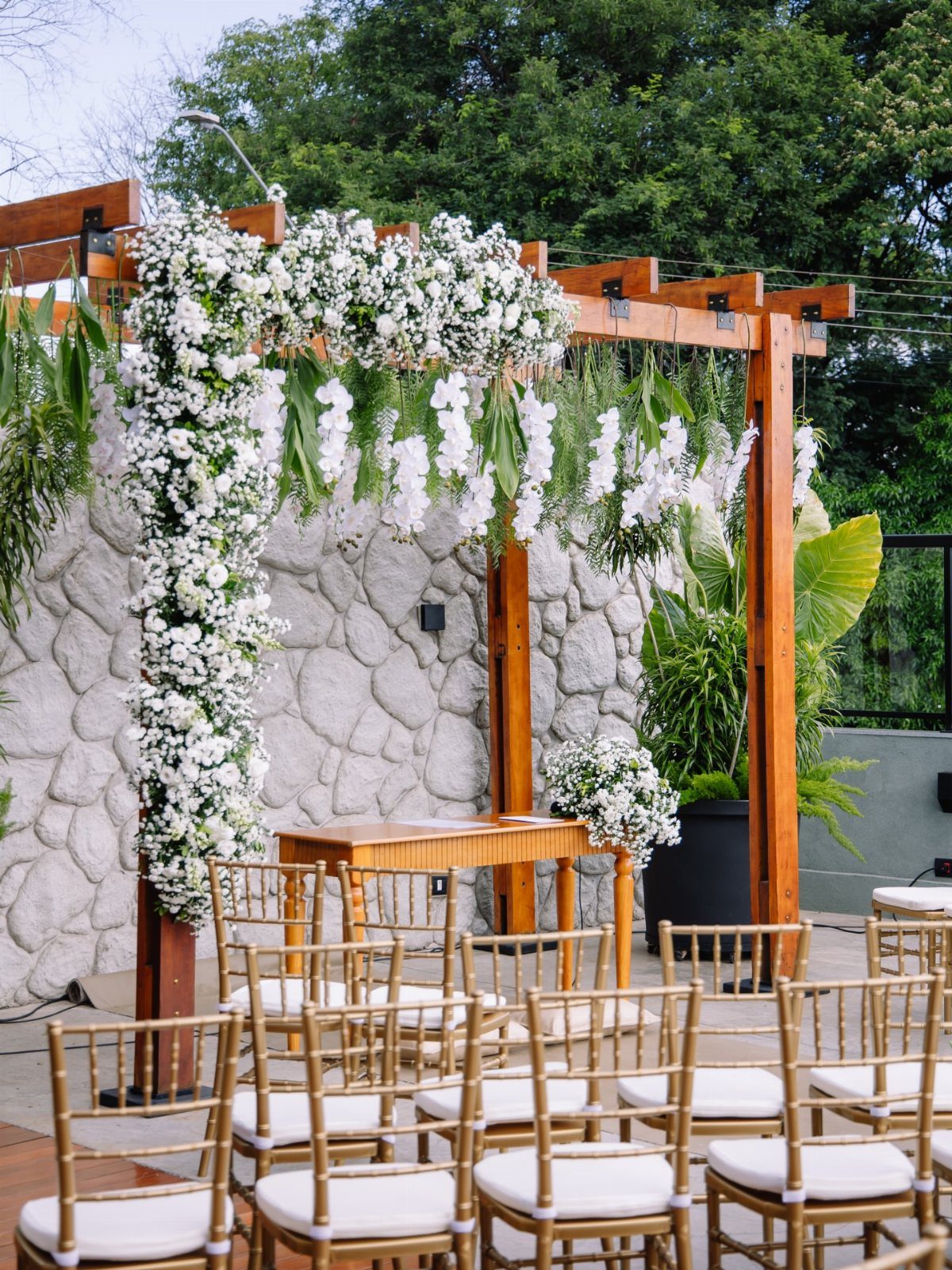 Wooden pergola decorated with white flowers as a focal point for wedding ceremony