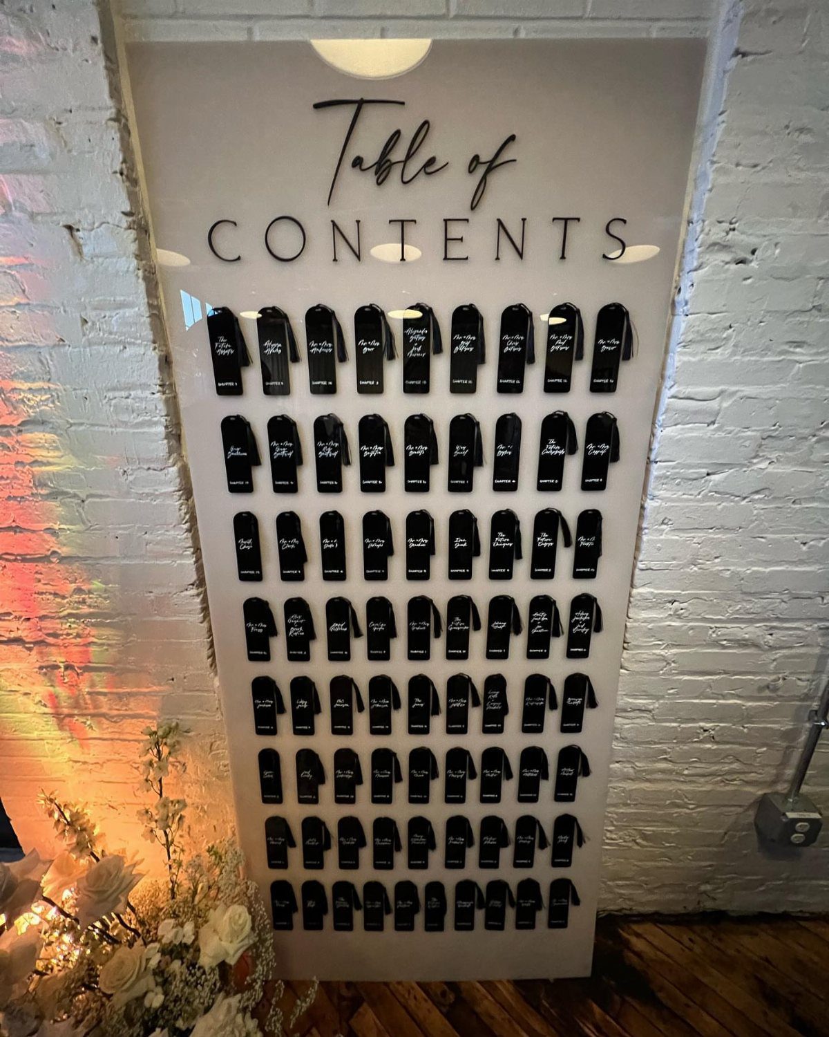 White seating chart board with black envelopes and Table of Contents text.