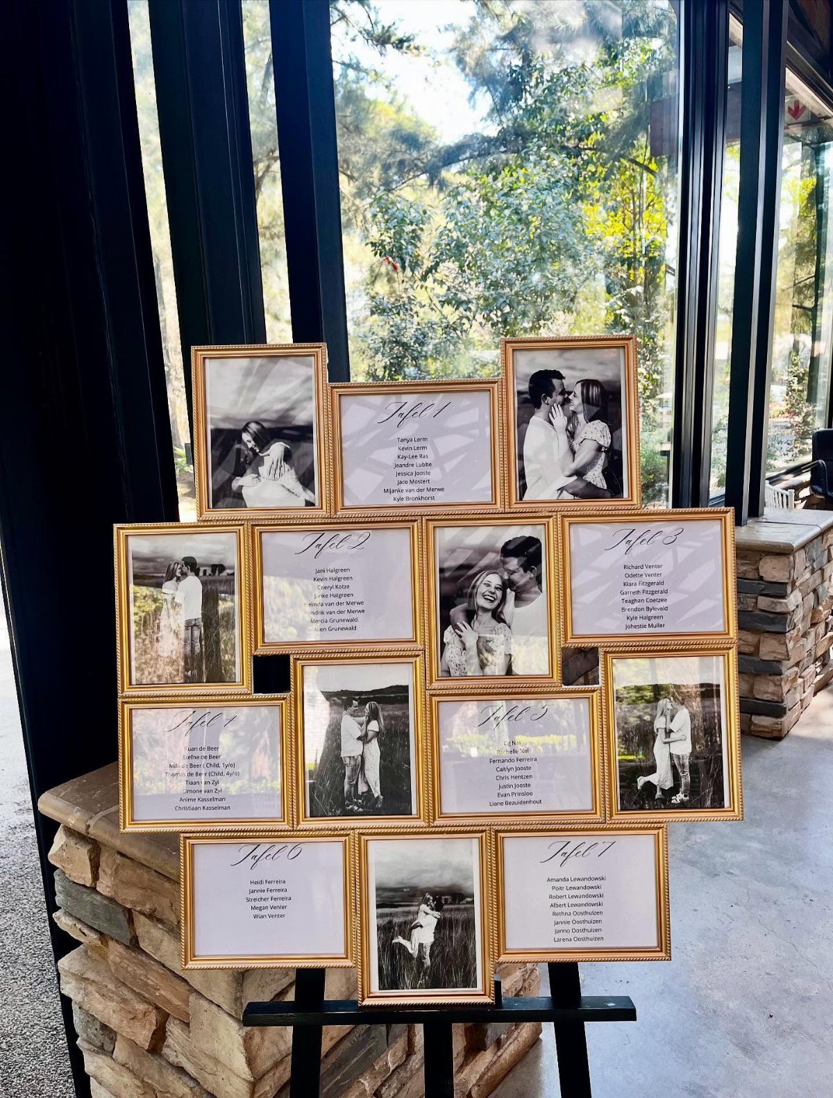 Gold vintage frames displaying wedding seating lists and couple photos on an easel.
