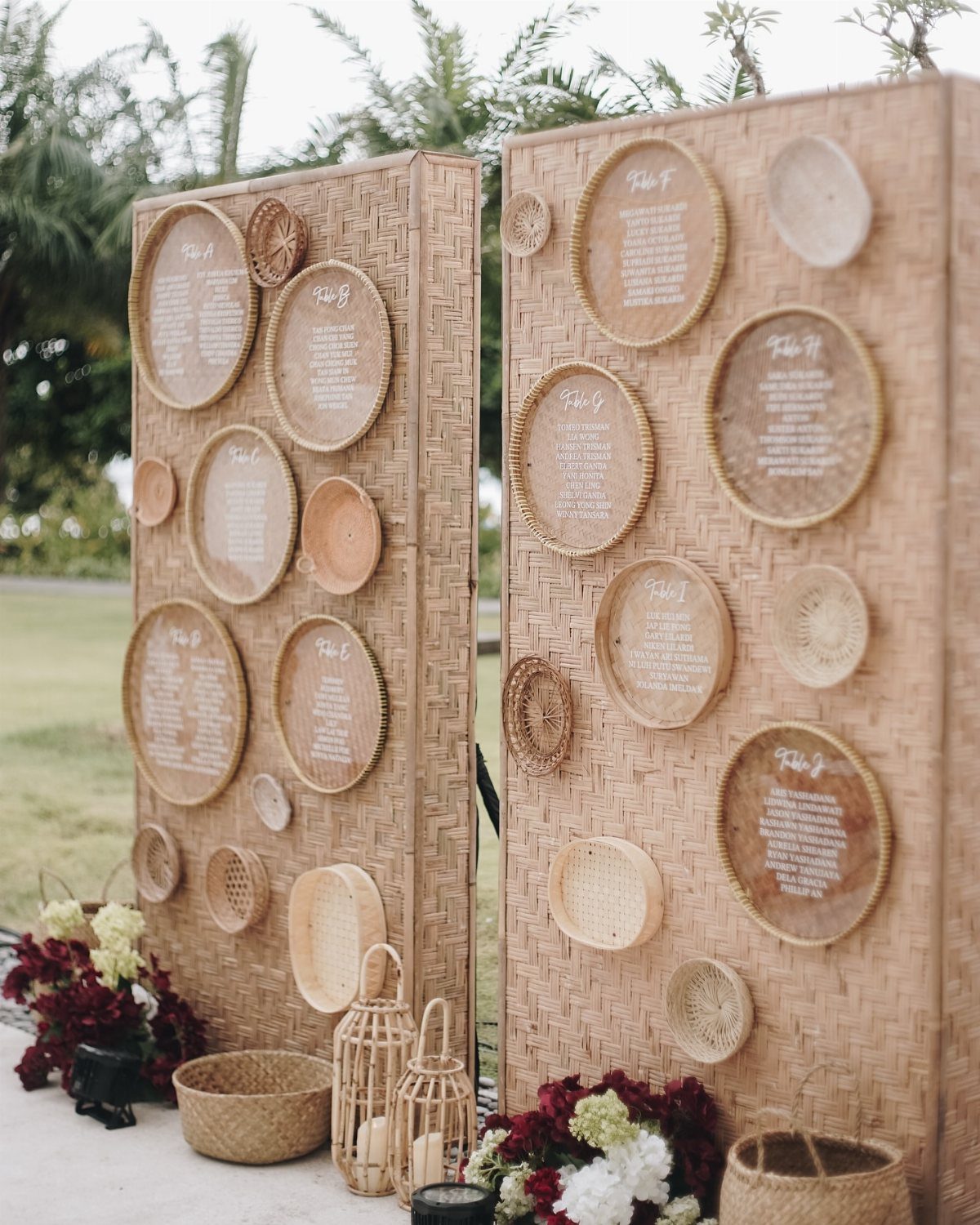 Woven wicker screens with round baskets serving as a wedding seating chart display.