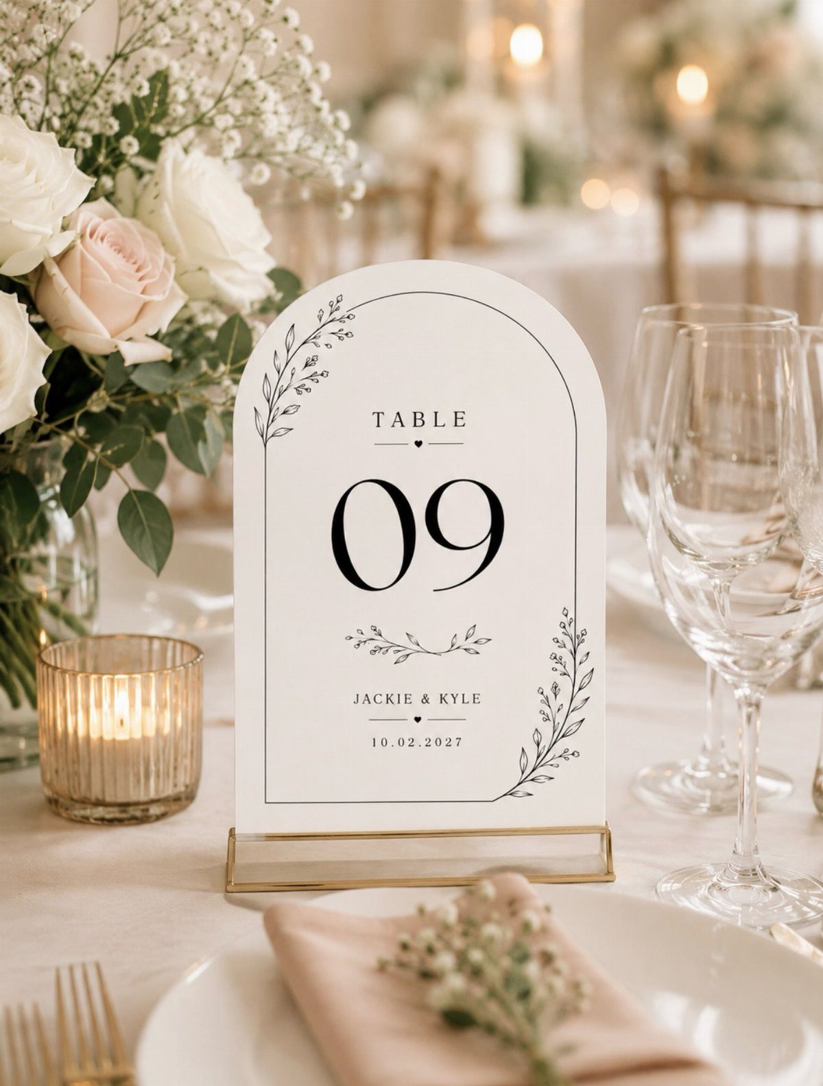 Arched white table number card with number 09 among white wedding flowers