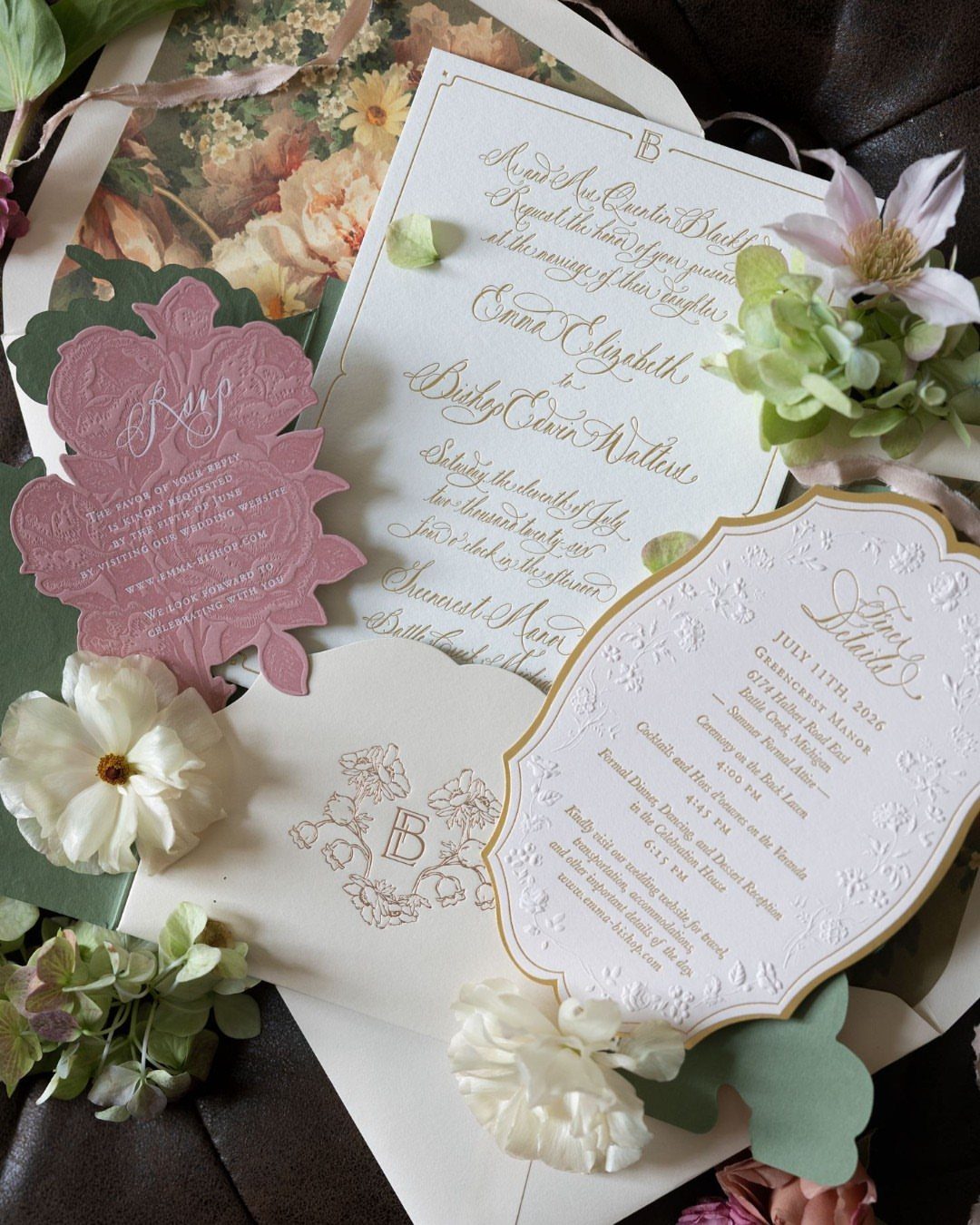 Wedding invitation suite with ivory and sage green stationery and white floral accents.