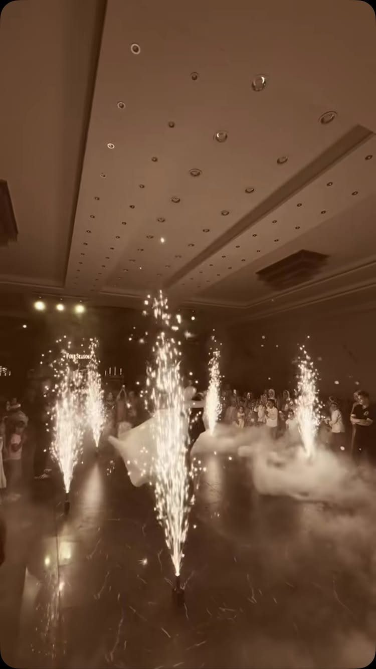 Cold spark fountains and low fog in a ballroom with guests in background