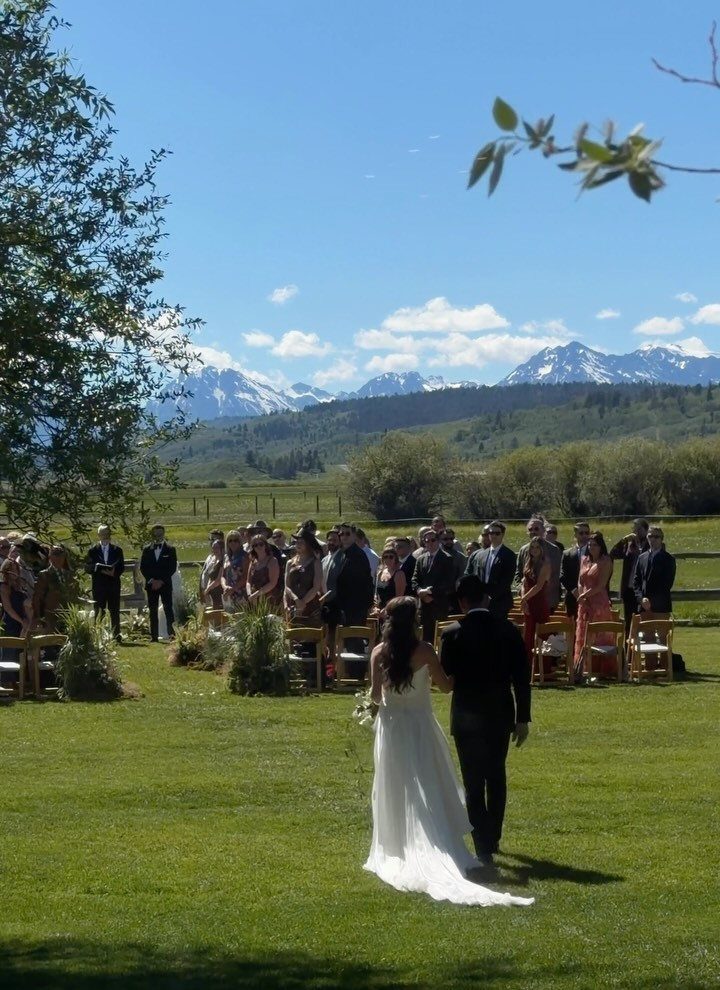 Bride and groom walking toward guests at an outdoor mountain wedding ceremony